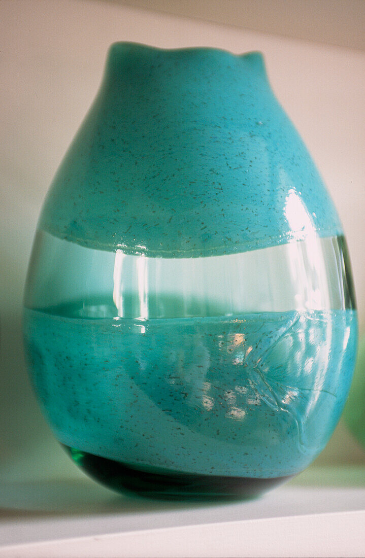 Detail einer modernen handgefertigten grünen Glasvase
