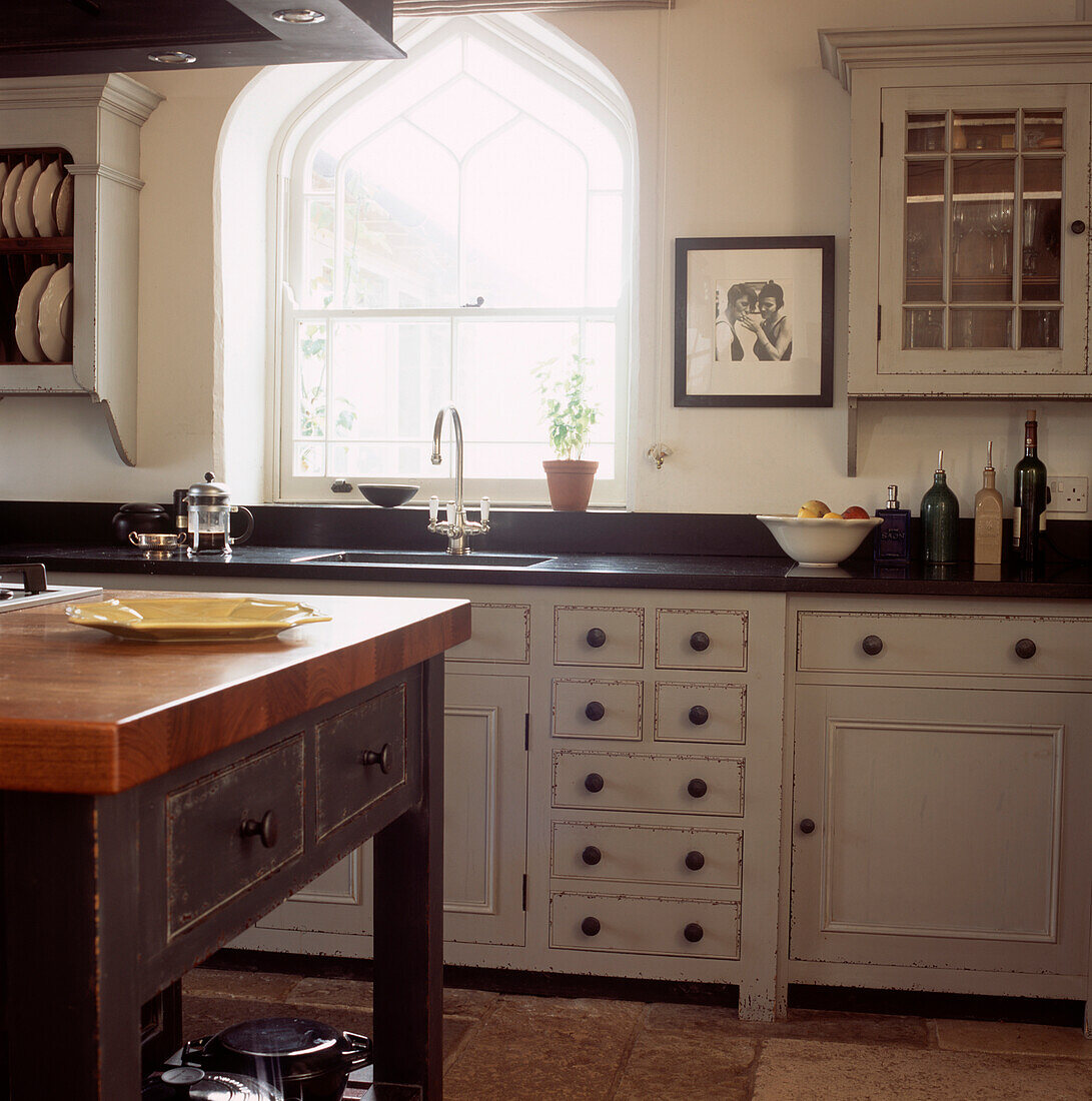 Landhausküche mit Bogenfenster, neutralen Schränken und schwarzen Granitarbeitsplatten