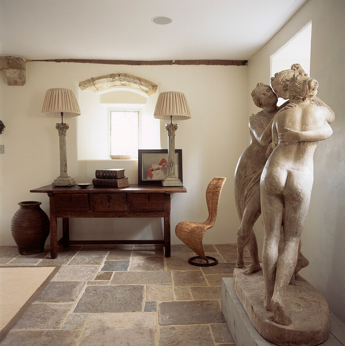 White entrance hall with stone floors and stone figurines