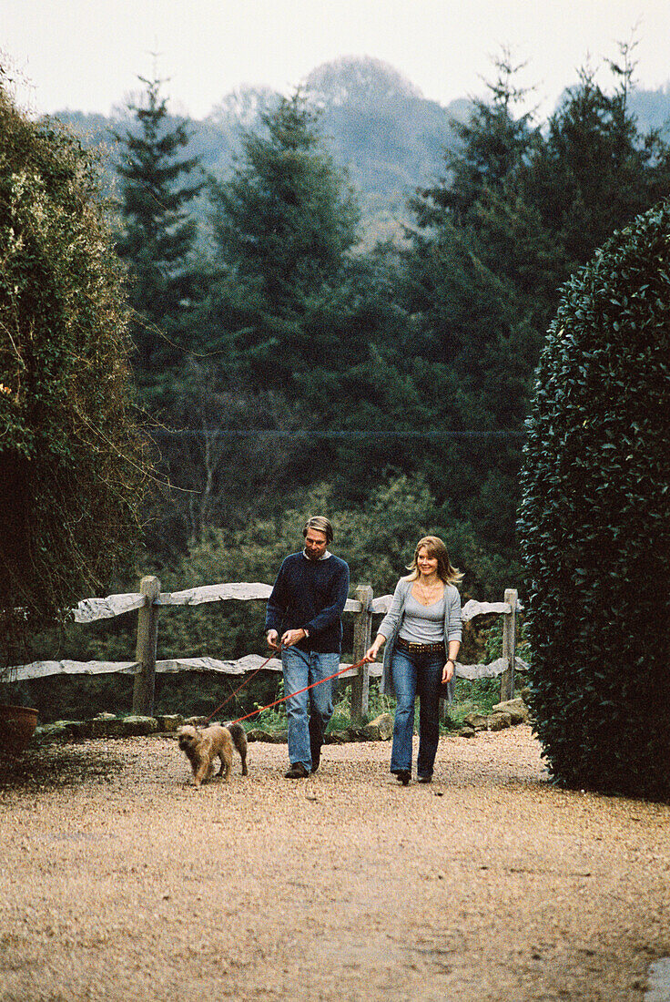 Ehepaar beim Spaziergang mit Hunden auf dem Land