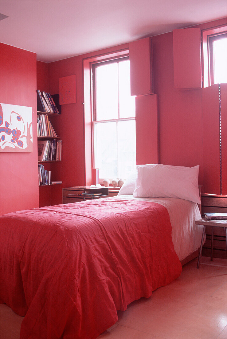 Contemporary dark pink bedroom with matching painted shutters and bed linen