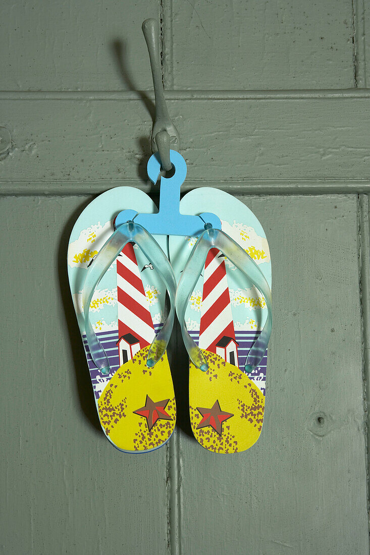 Lighthouse flip-flops hanging on the back of a door