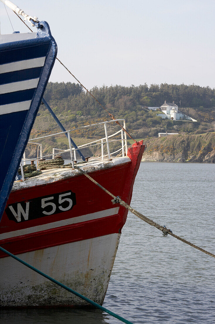 View of lighthouse with two fishing boat hulls in the foreground