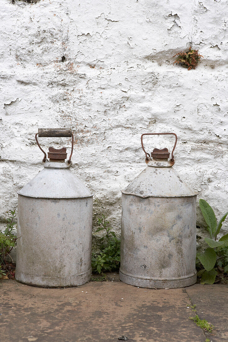 A Pair of vintage metal cans against exterior wall