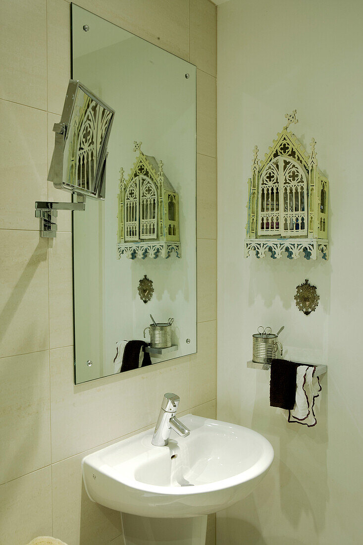 Als Kontrast zu den modernen Einrichtungsgegenständen hängt ein hübscher antiker Miniaturschrank im gotischen Stil an der Wand