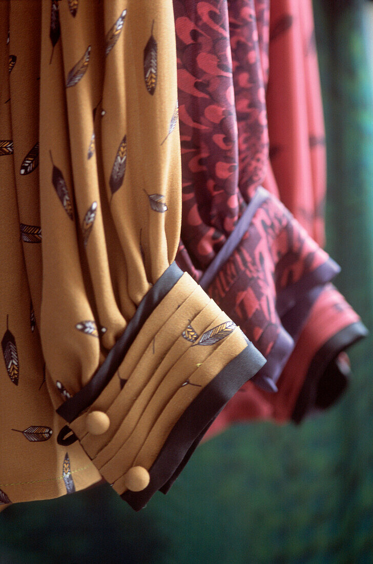 Detail of women's shirt sleeves hanging on a rail