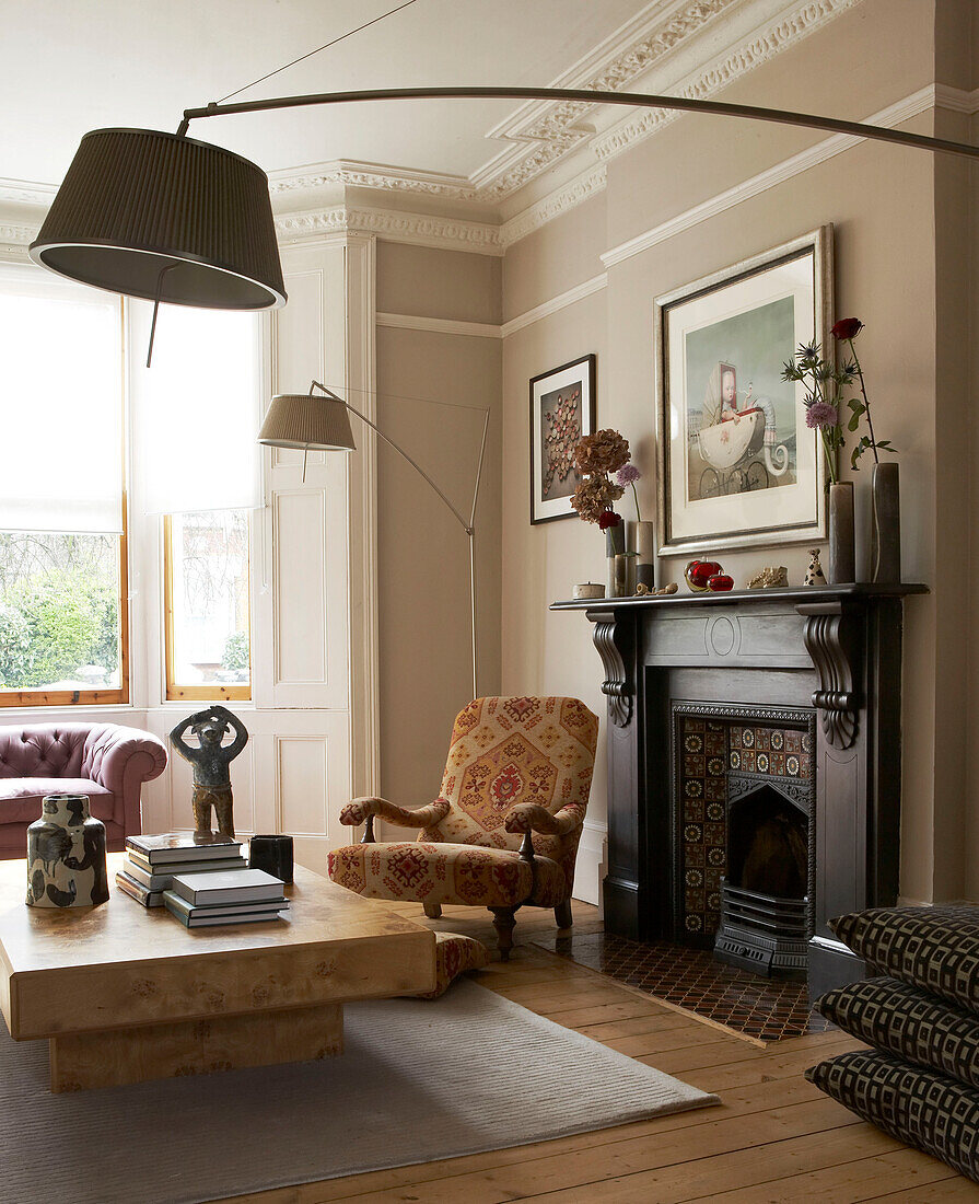 Victorian fireplace with and floor lamps in living room of in London townhouse, UK