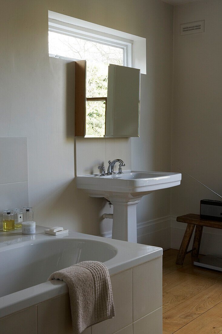 Spiegelschrank über weißem Keramikwaschbecken in einem Badezimmer eines Londoner Stadthauses, UK