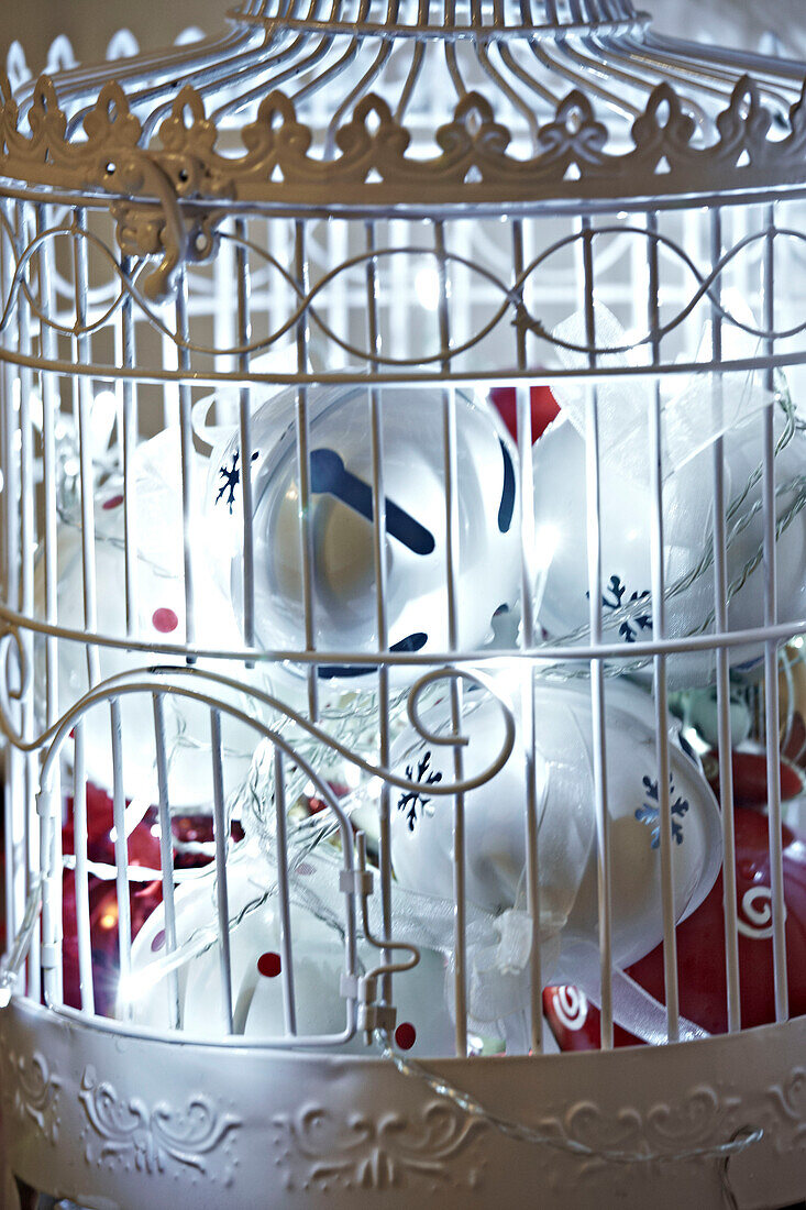 Weißer dekorativer Vogelkäfig mit Weihnachtsdekoration in Großaufnahme