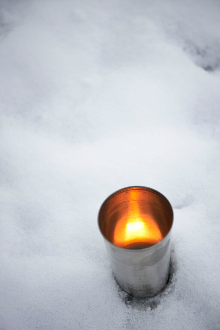 Metallisches Teelicht im Schnee