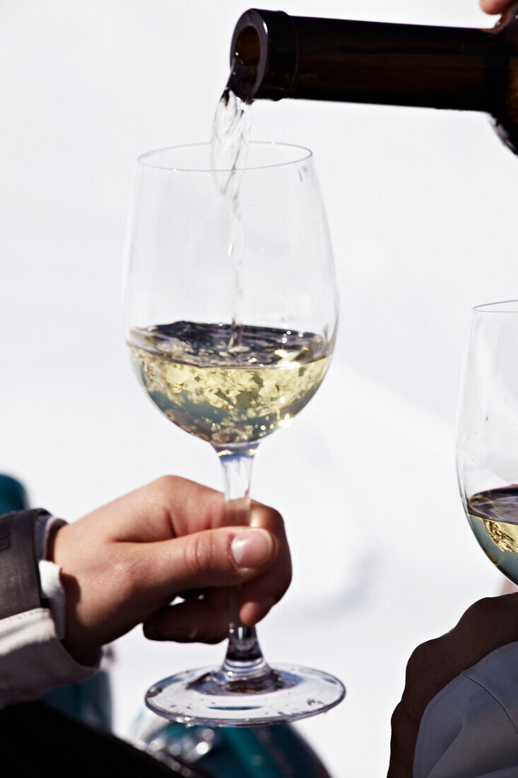 Einschenken von Weißwein in ein Weinglas in Zermatt, Schweiz