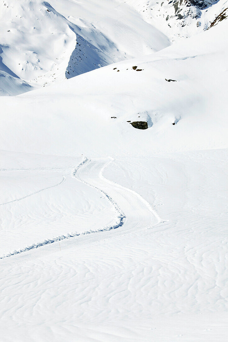 Skispuren im Schnee am Berghang in Zermatt, Wallis, Schweiz