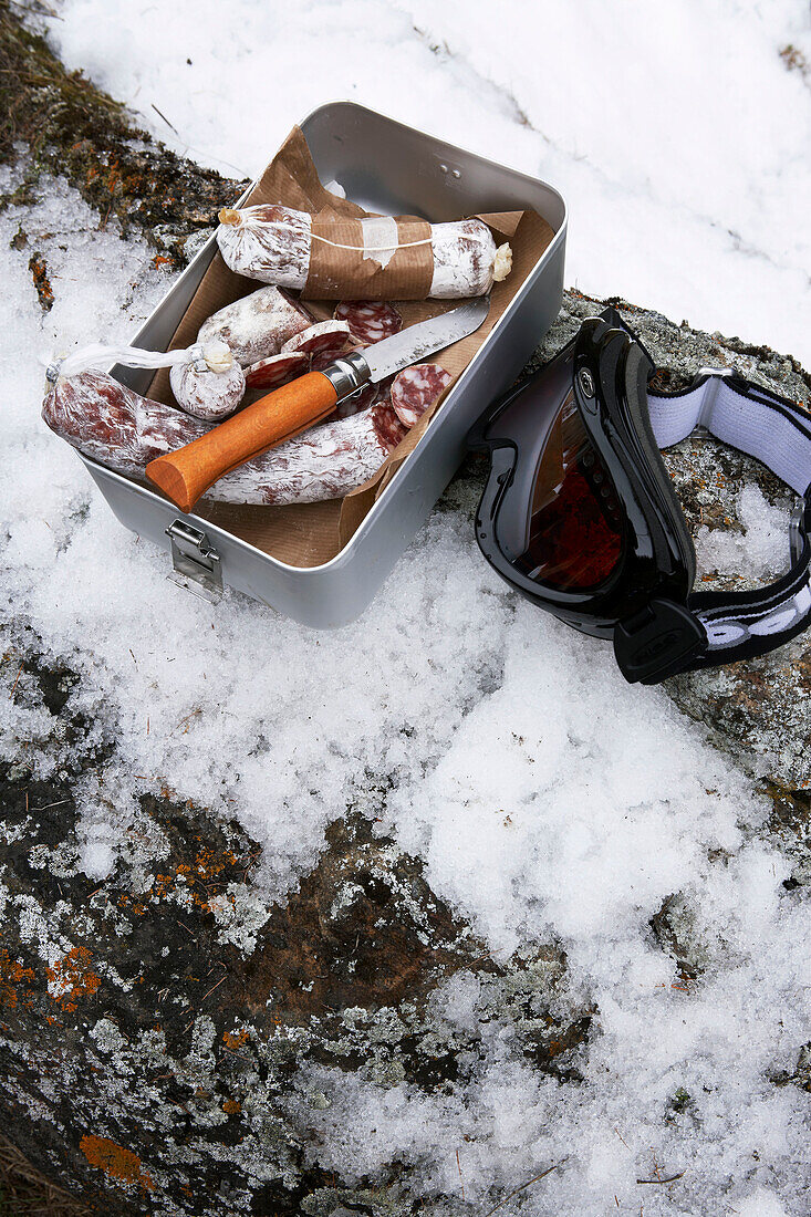 Dried sausage in tin with skiing goggles, Zermatt, Valais, Switzerland