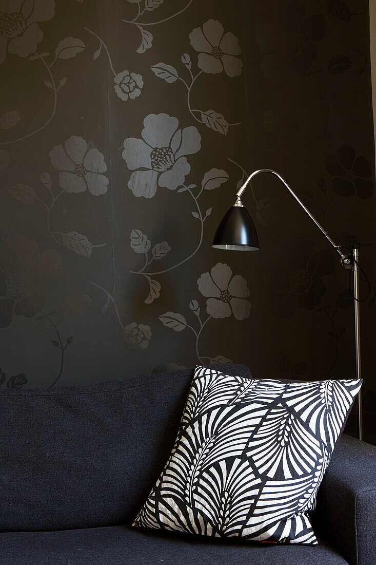 Leaf patterned cushion with floral wallpaper in London townhouse, England, UK