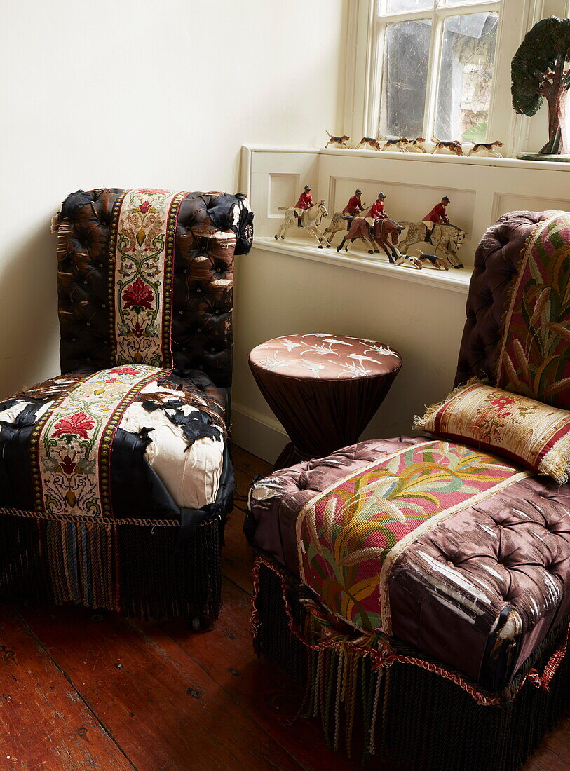 Threadbare chairs with figurines of the hunt in Cumbrian home, England, UK