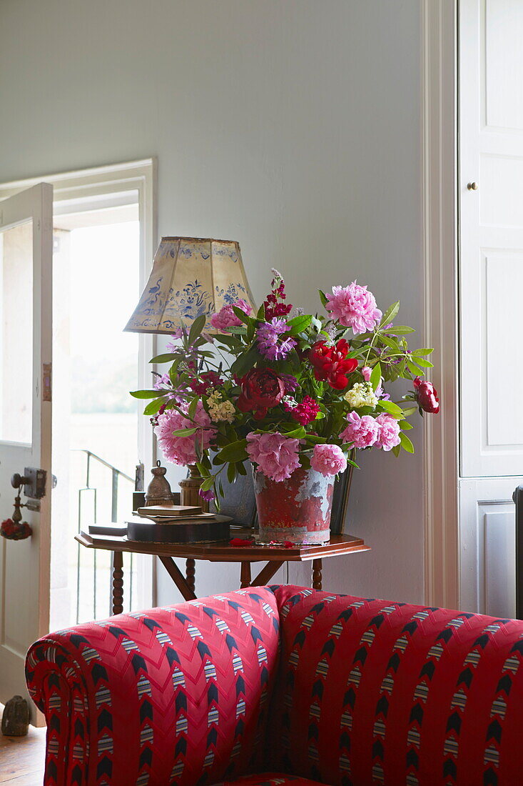 Schnittblumen und gepolstertes Sofa in einem Bauernhaus in Cumbria, England, UK