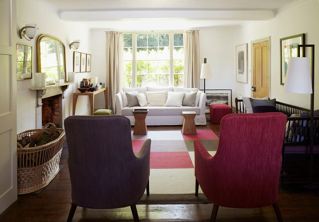 Wohnzimmer mit kariertem Teppich und gepolsterten Stühlen