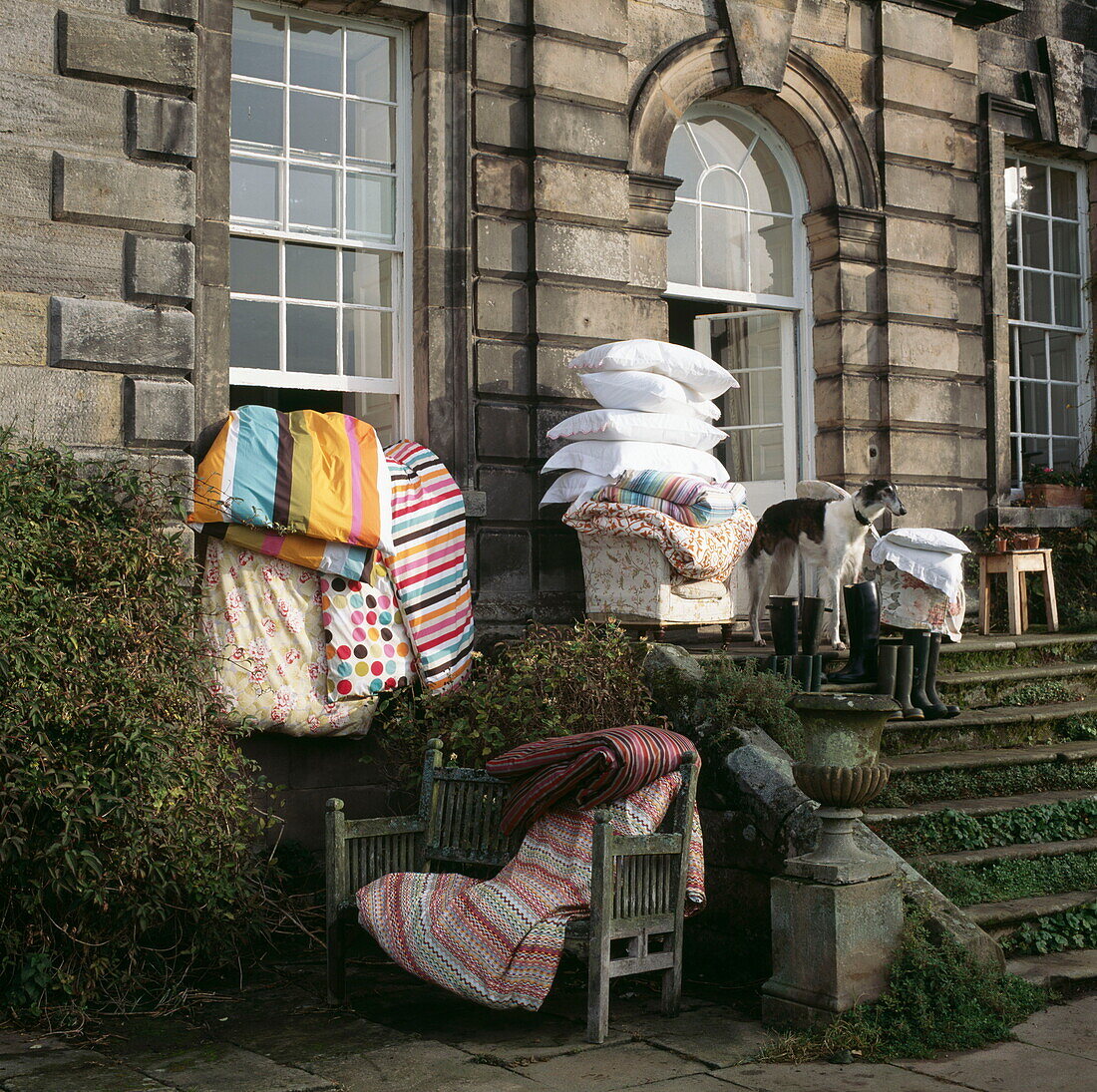 Kissen und Bettdecken werden auf den Stufen eines alten Londoner Hauses gelüftet, UK