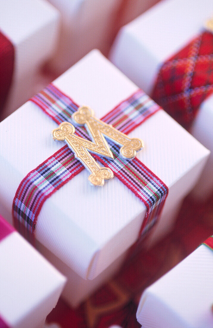 Weihnachtsgeschenkboxen mit Band und Folienbuchstaben verschnürt