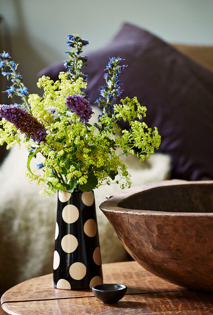 Schnittblumen in gepunkteter Vase mit Holzschale in einem Einfamilienhaus, Rye, East Sussex, England, UK