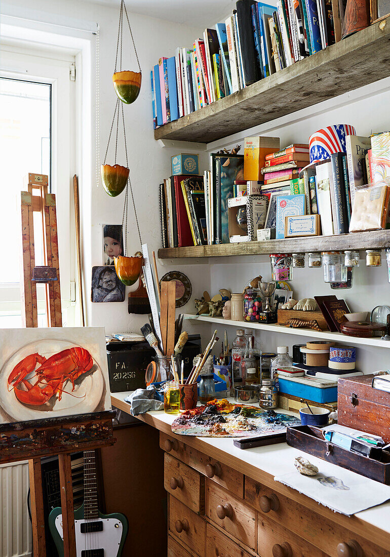 Books and art equipment with easel in Hackney studio, East London, UK