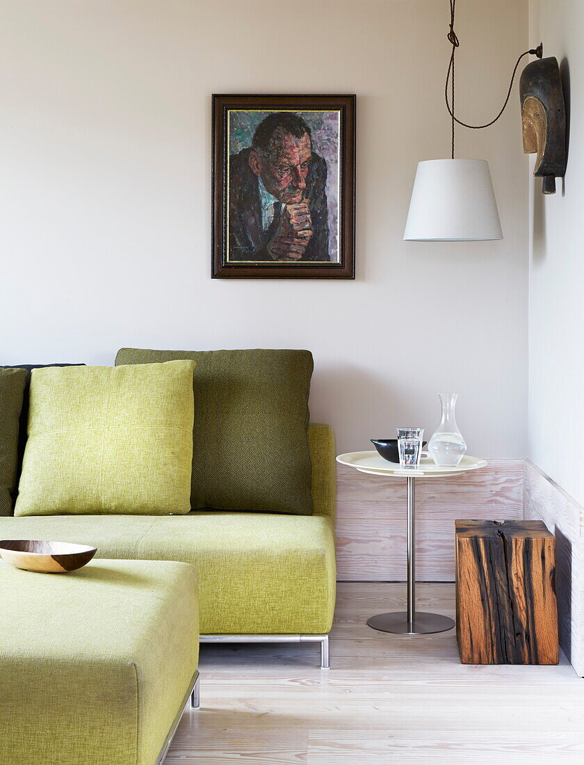 Lime green sofa and cushions with artwork in contemporary London home, England, UK
