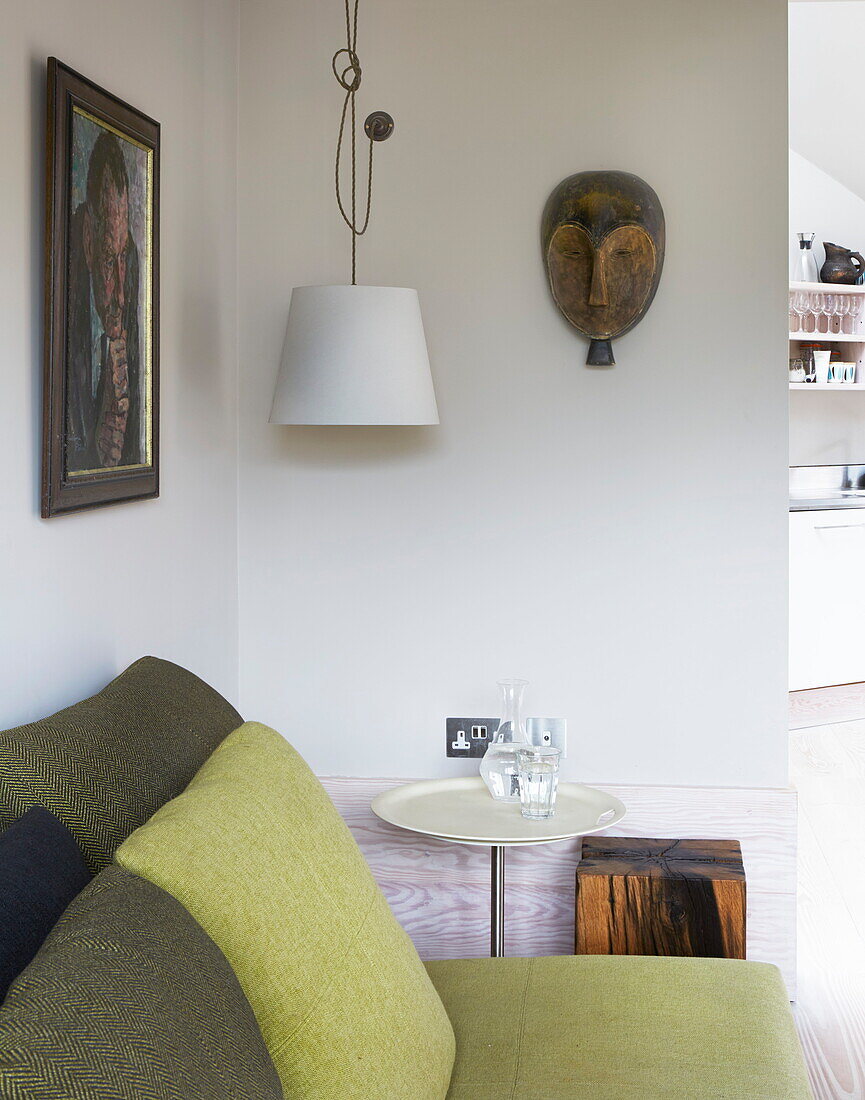 Lindgrünes Sofa und Kissen mit Kunstwerken in einem modernen Haus in London, England, UK