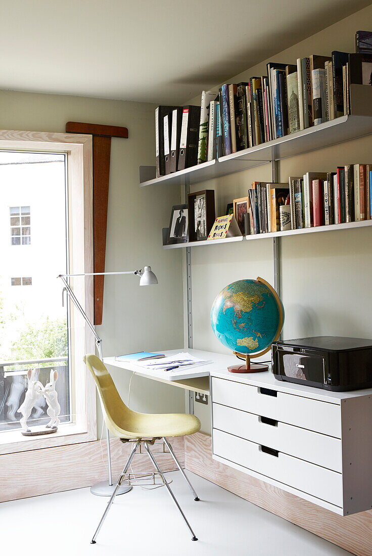 Schreibtisch mit Bücherregalen und Globus in einem modernen Haus in London, England, Vereinigtes Königreich