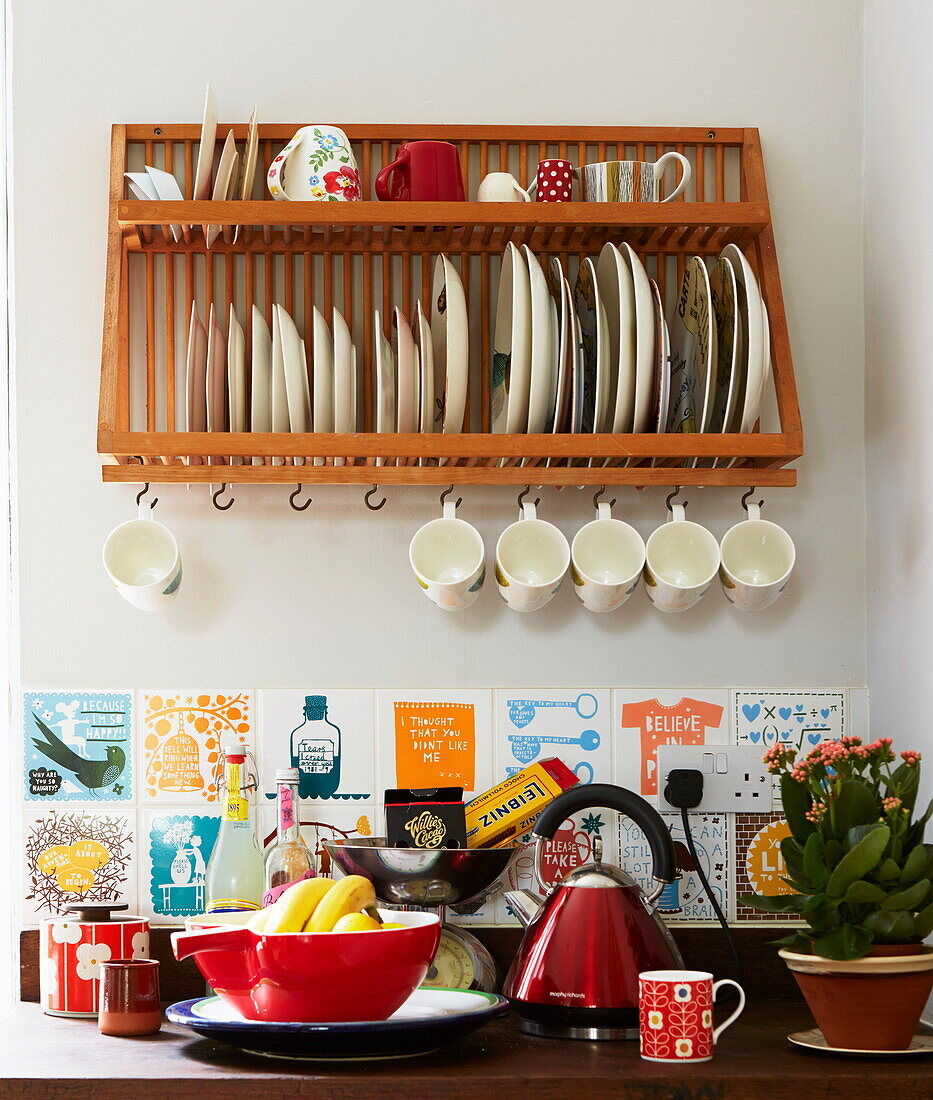 Plate rack and kettle with tiled splashback in kitchen of London home, England, UK