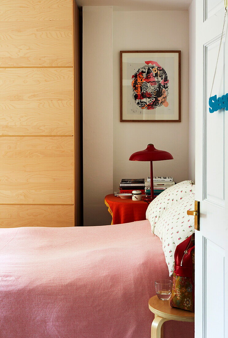 Rosa Bettdecke und hölzerner Kleiderschrank in einem Londoner Haus, England, UK