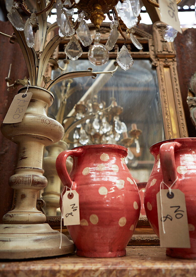 Gefleckte Krüge mit Lampenfuß und Vintage-Spiegel in einem Antiquitätengeschäft in Evershot, Dorset, Kent, Großbritannien