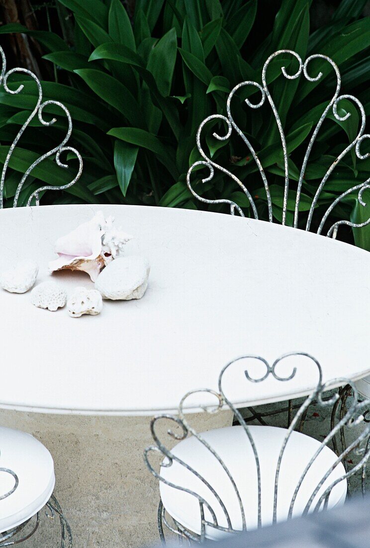 Altmodischer weißer Gartentisch mit Muscheln