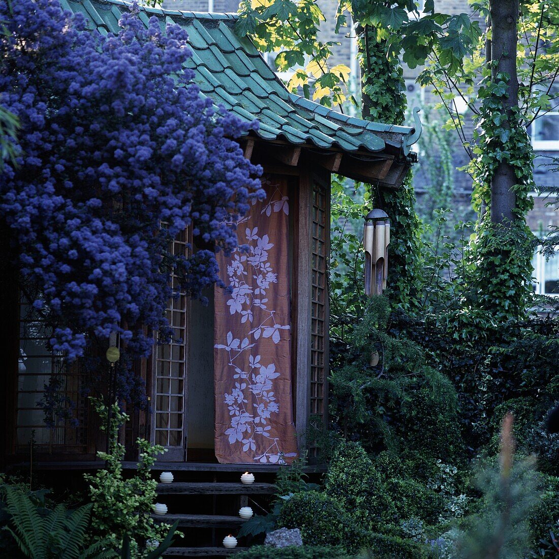 Summer hut in garden among flowers