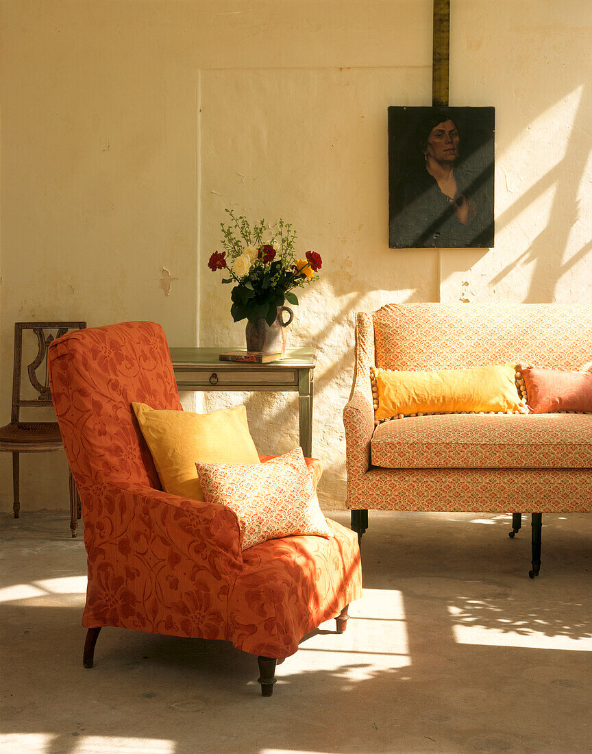 Softe, pfirsichfarbene Polstermöbel in weiß getünchtem Wohnzimmer