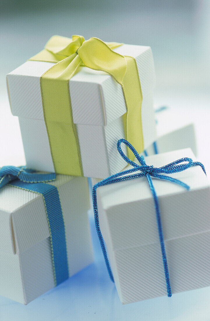Blaue und gelbgrüne Schleife auf weißen Geschenkschachteln