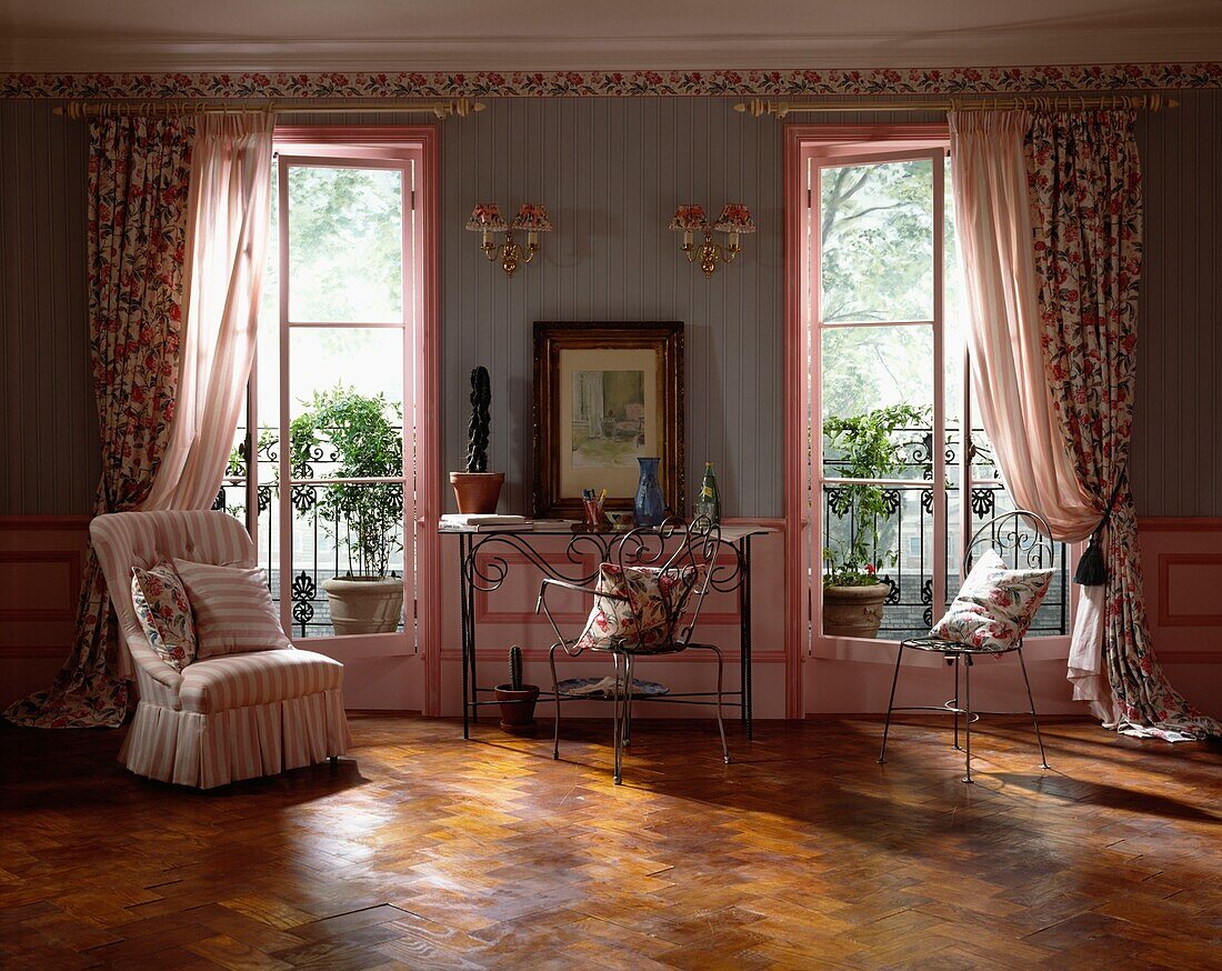 Co-ordinated pink floral fabrics in living room with French doors and balconies