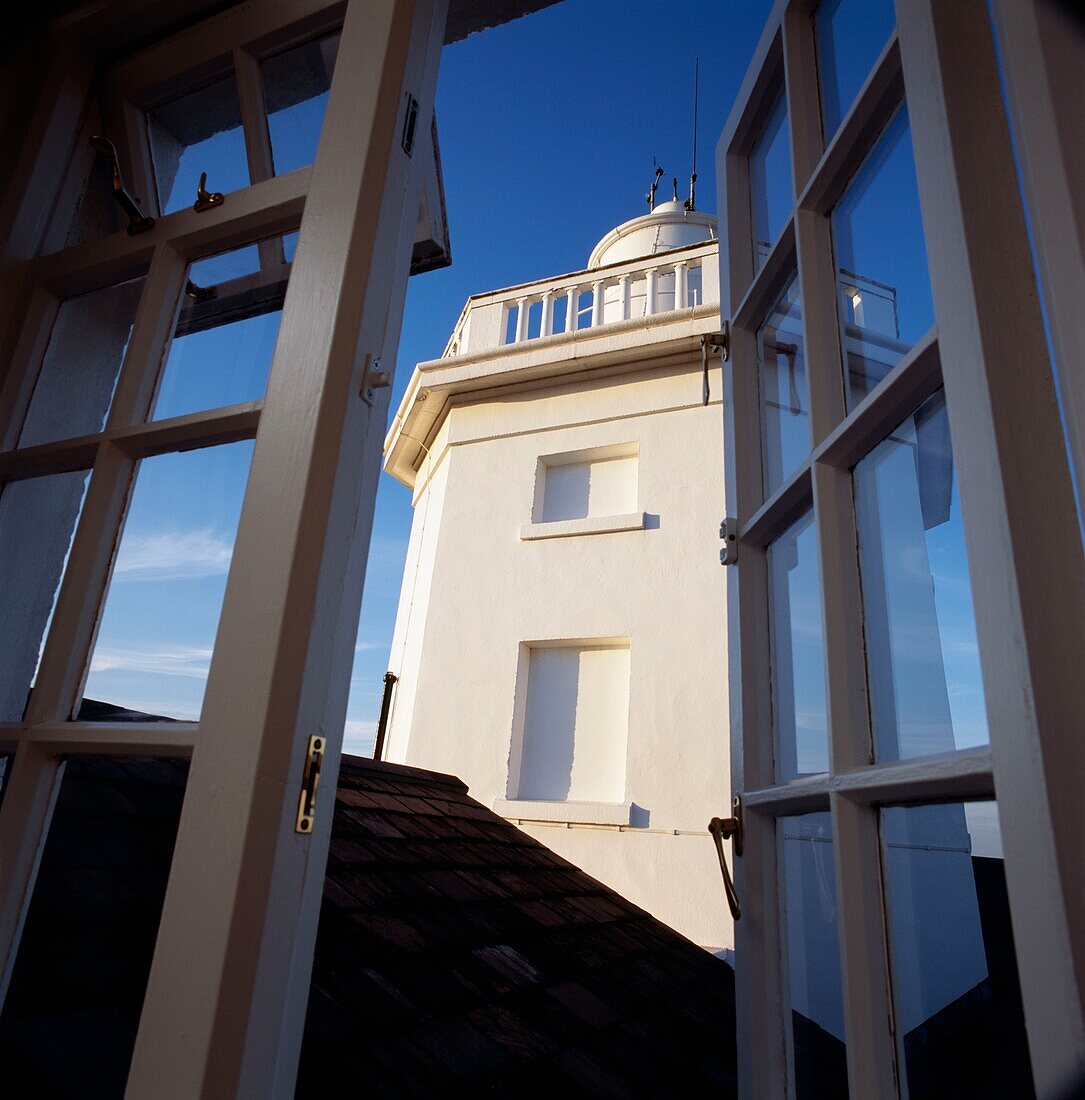 Whitewashed lighthouse viewed through open door