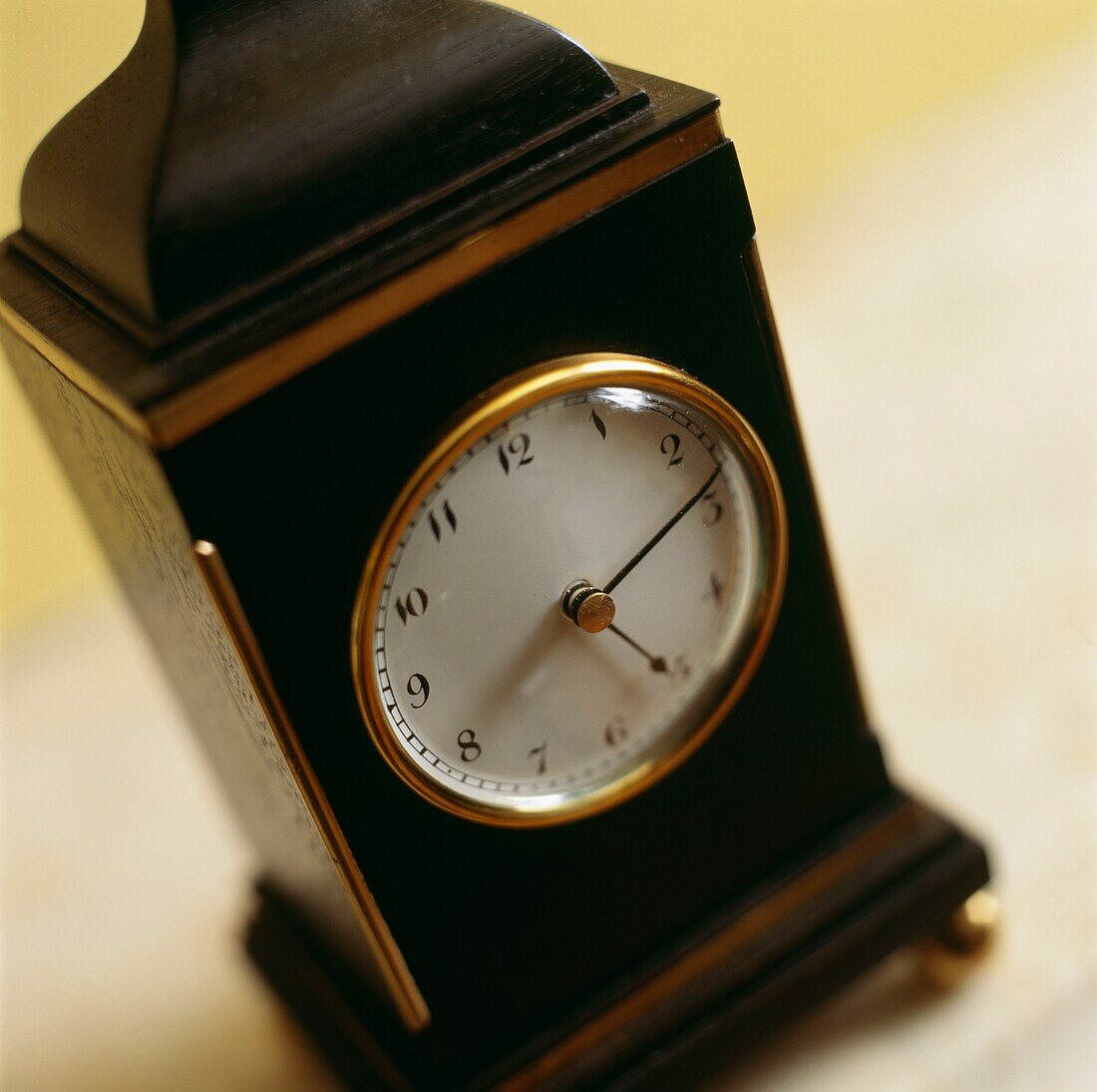 Selektiver Fokus auf das Zifferblatt einer vergoldeten Uhr aus dunklem Holz