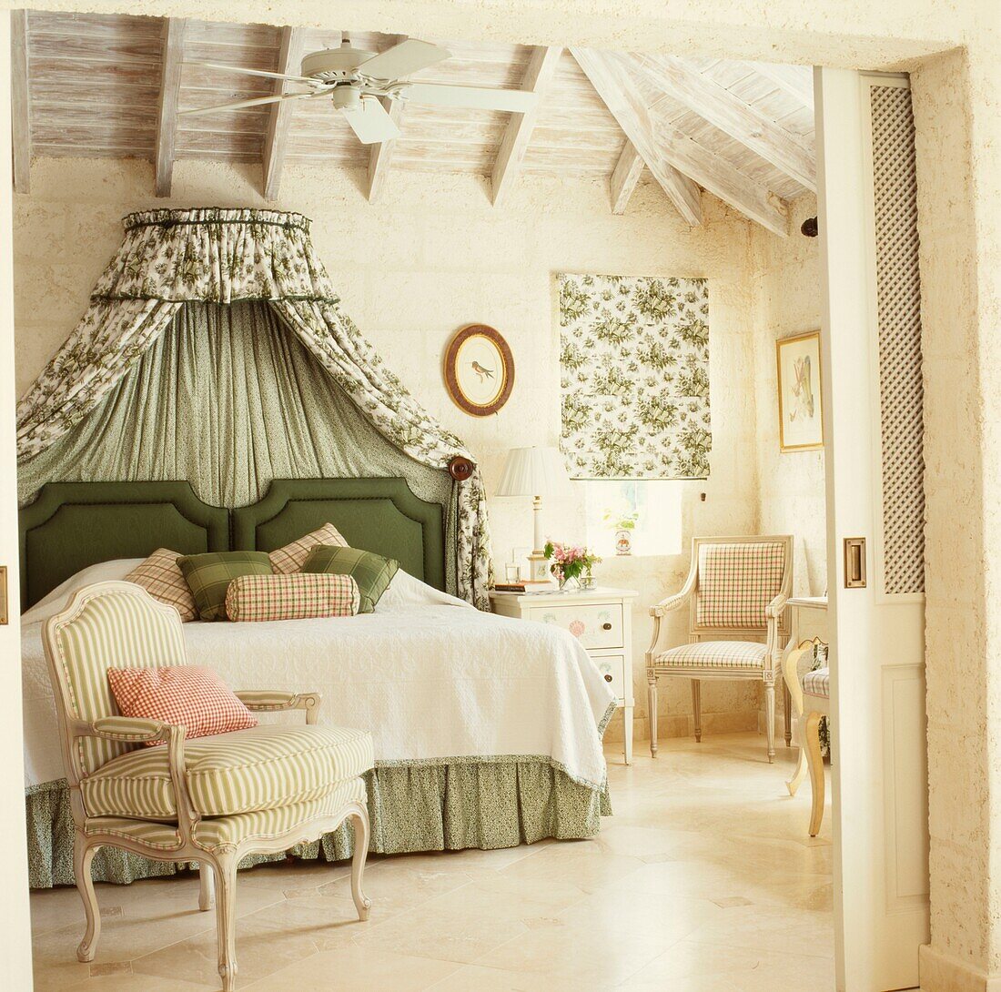 Striped armchair in bedroom with co-ordinated bed canopy and blinds 