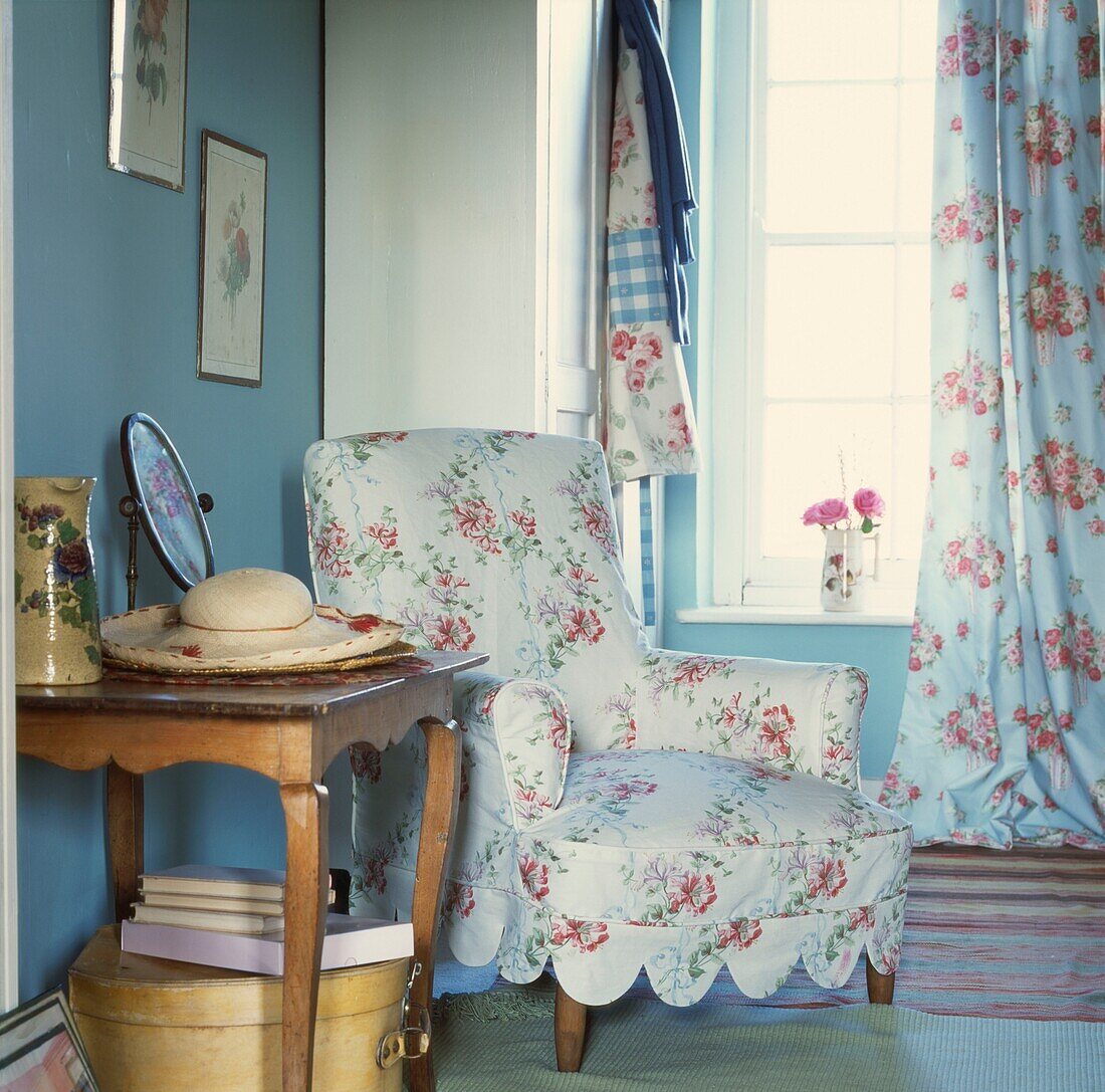 Floral gemusterter Sessel mit Beistelltisch in einer Zimmerecke am Fenster