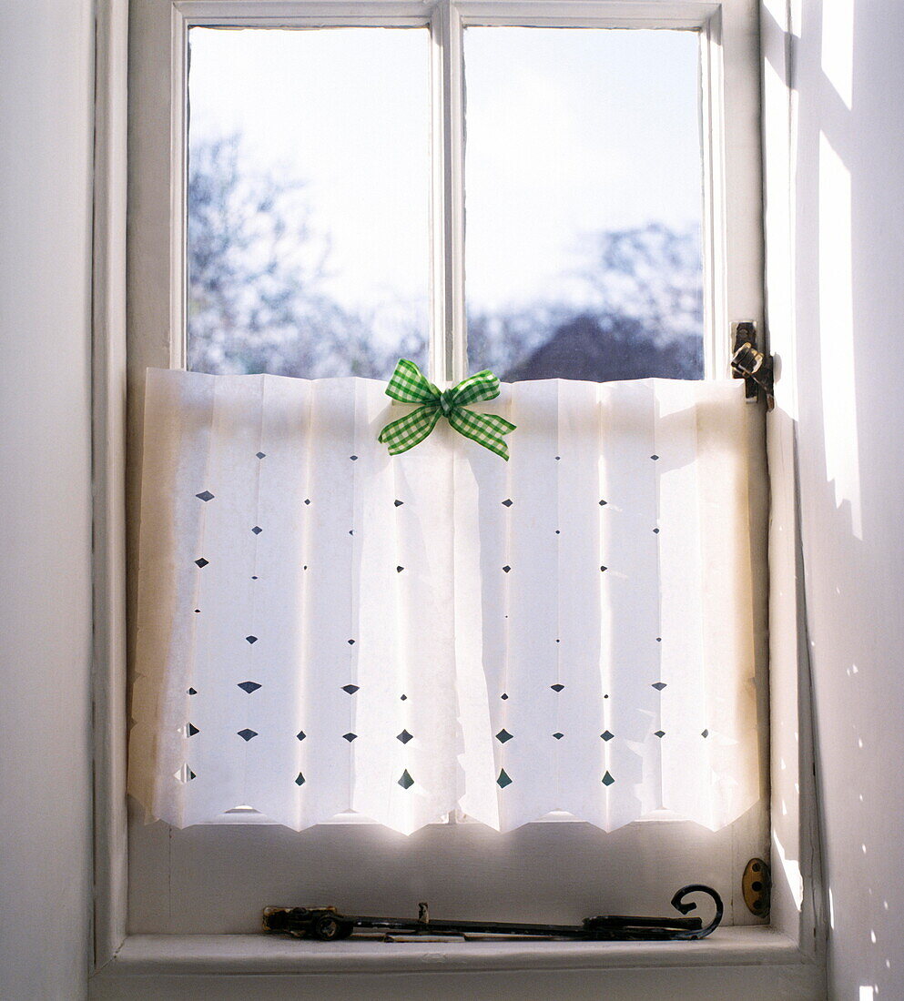 Paper cut window shade with green gingham bow