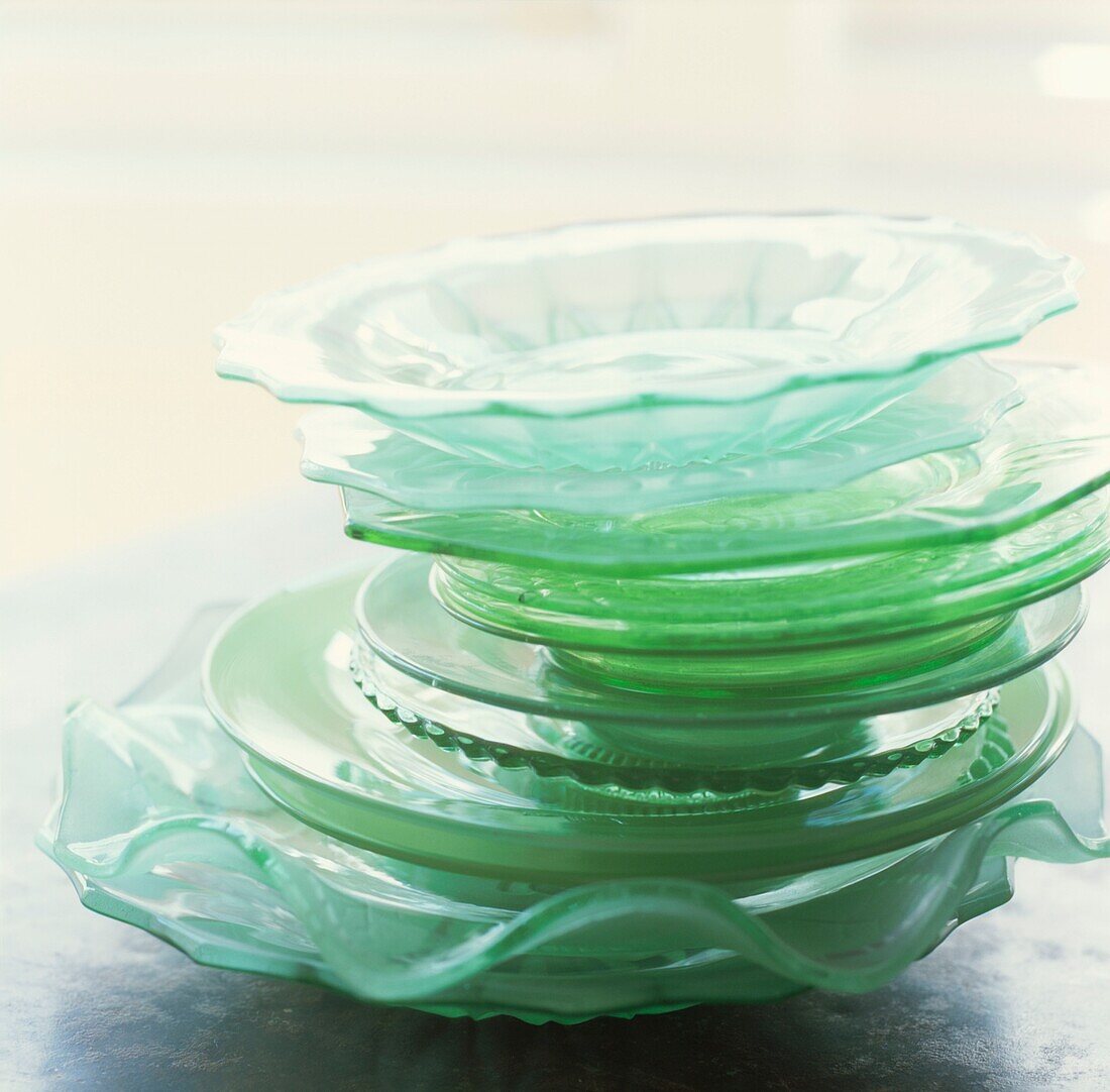 Stack of green coloured and glass side plates