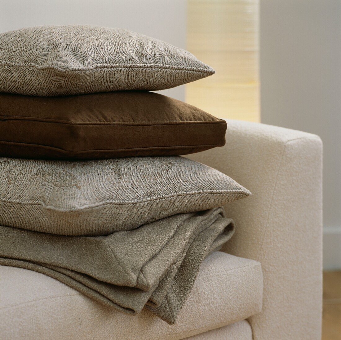 Pile of cushions on cream armchair