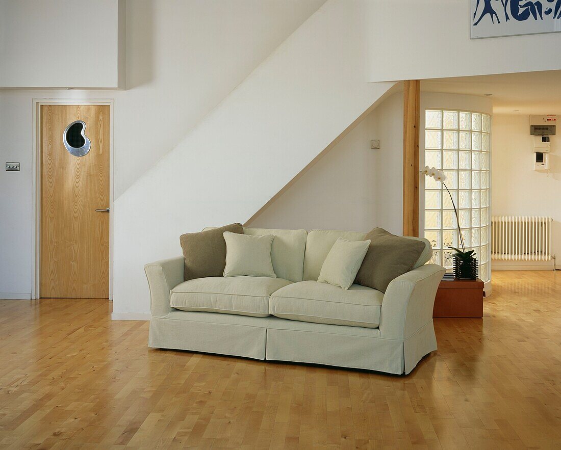 Cream sofa in open plan living room with glass bricks