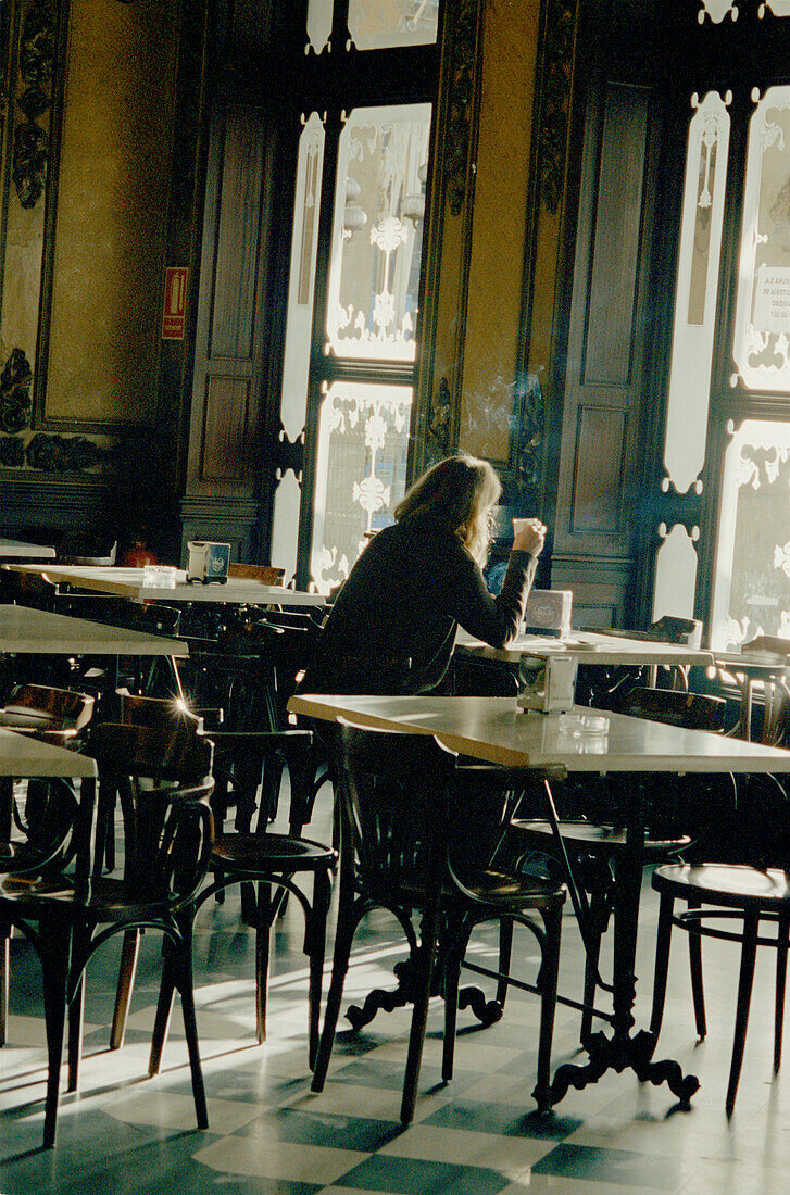 Frau sitzt an einem Tisch in einer eleganten Bar in Pamplona