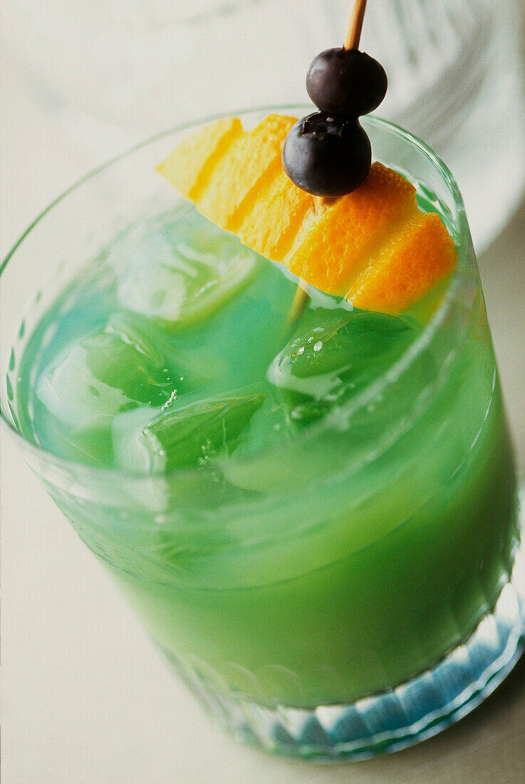 Harakiri-Cocktail aus Midori-Melonenlikör, weißem Rum und Zitronensaft, garniert mit Orangen und Blaubeeren
