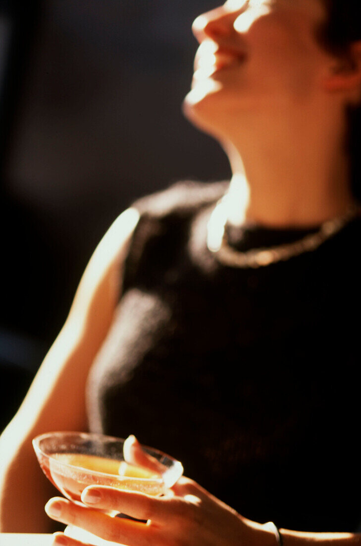 Frau hält einen Cocktail in einer Bar