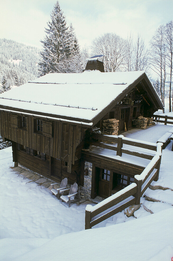 Typisches Alpenchalet aus Holz in verschneiter Landschaft