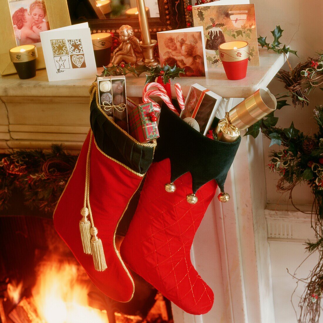 Two Christmas stockings hang beside open fire