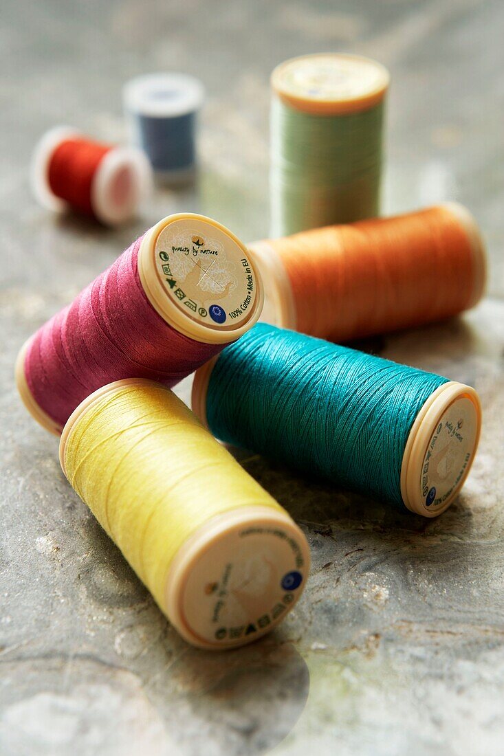 Bright multi-coloured reels of cotton on a surface